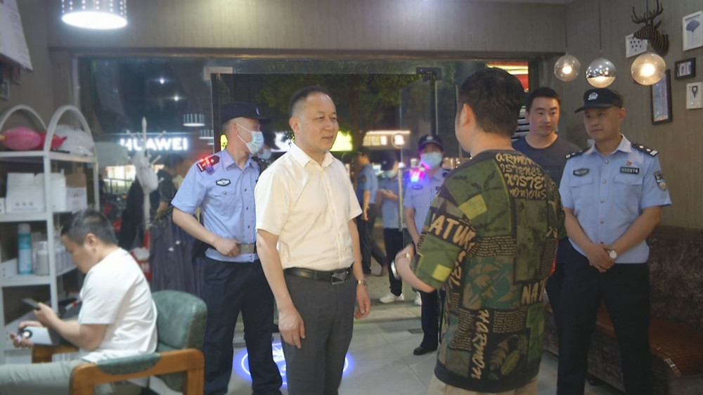 图为王中龙在方圆荟附近与一理发店店家交流时的情景.jpg