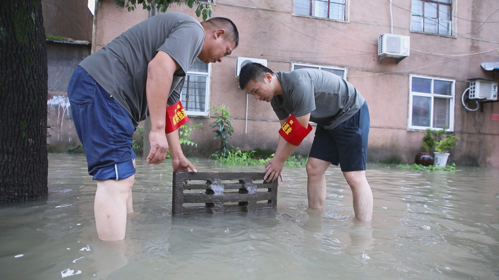 图为双港镇退役军人 基干民兵正在拉开窨井盖紧急排水。.jpg