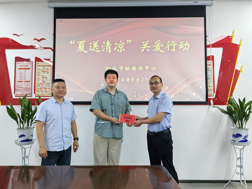图为市融媒体中心党组书记、主任徐基胜和党组成员、副主任吴文舟为派驻石窑村工作队队员李玉衡送上慰问金。.jpg
