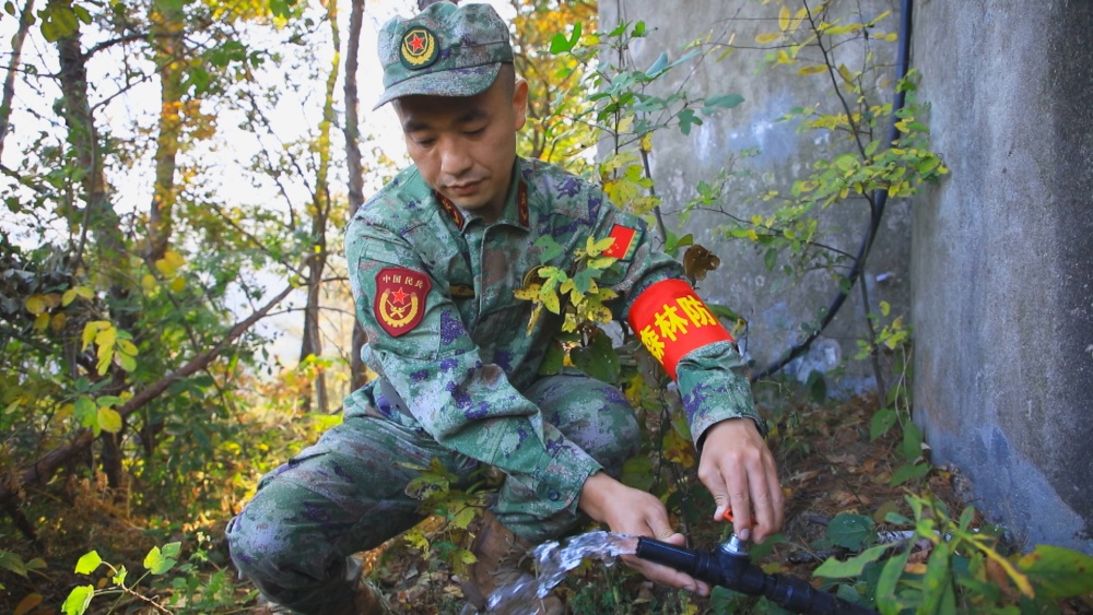 图为龙眠街道龙眠村护林员正在检查蓄水池蓄放水功能.jpg